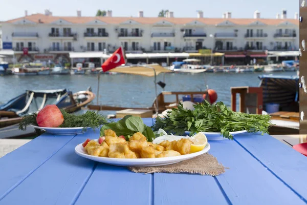 Kızarmış balık dilimleri ile yeşil ve mavi ahşap masa açık havada limon