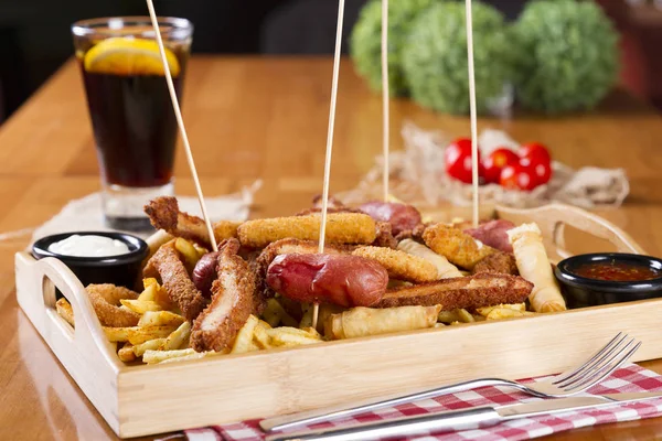 Tabloda kızarmış taze bira tabak patates kızartması, tavuk Nuggets, peynir parmak, soğan halkaları, sosis, acı sos ile deef