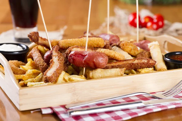 Tabloda kızarmış taze bira tabak patates kızartması, tavuk Nuggets, peynir parmak, soğan halkaları, sosis, acı sos ile deef