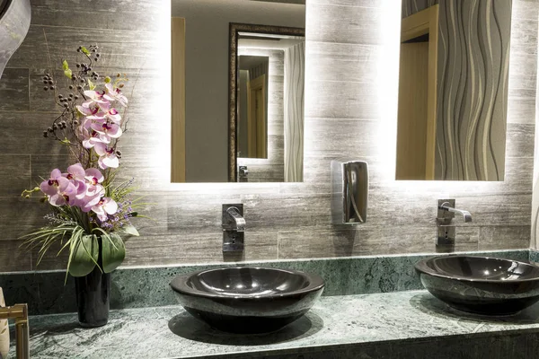 Yeşil özel tasarım mermer Counter, siyah Top Counter lavabo, güzel pembe çiçek, krom musluk, metal sabun dispenseri ve bej dokulu duvar karoları, ofis binası içinde ticari ortak banyo