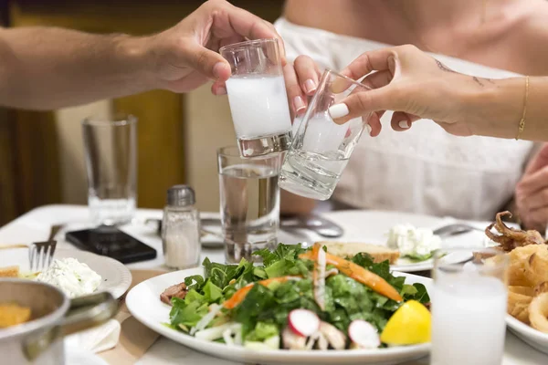 Üç arkadaş restoranda Türk geleneksel rakı içki içme