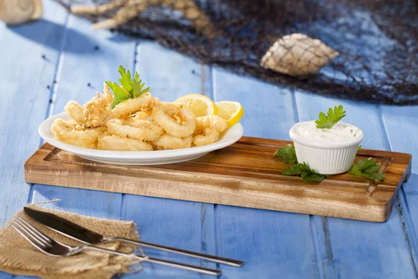 Zeytinyağı ile beyaz tabak lezzetli deniz ürünleri altın kızarmış gevrek kalamar halkaları 