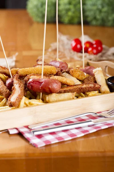 Tabloda kızarmış taze bira tabak patates kızartması, tavuk Nuggets, peynir parmak, soğan halkaları, sosis, acı sos ile deef