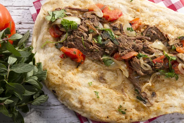 Türkçe ve Arapça geleneksel Delicious ramazan kuzu sığır eti kebabı soğan, domates, maydanoz ve rustik beyaz ahşap zemin üzerinde özel sosu ile flatbreadserving üzerinde.