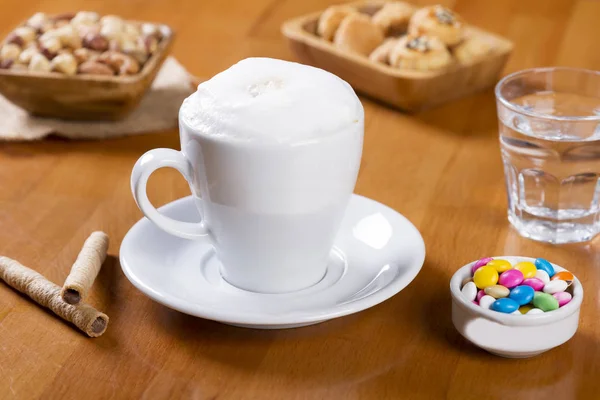 Delicioso Capuchino Taza Blanca Con Espuma Blanca Bombones Nueces Capuchino — Foto de Stock