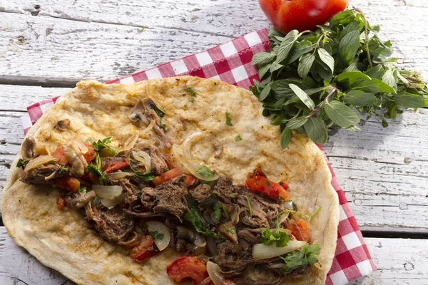 Türkçe ve Arapça geleneksel Delicious ramazan kuzu sığır eti kebabı soğan, domates, maydanoz ve rustik beyaz ahşap zemin üzerinde özel sosu ile flatbreadserving üzerinde.