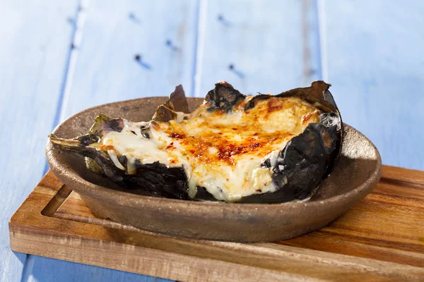 Lezzetli bütün sakat plaka bambu kesme tahtası üzerinde Zeytinyağlı patlıcan veya karniyarik dolması 