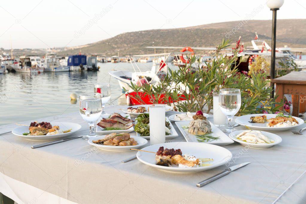 Table setting with different seafood meals at outdoor cafe 