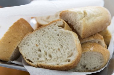 Türk ve Yunan geleneksel beyaz dilimlenmiş kepekli ekmek peçete ahşap masa arka plan üzerinde ile metal pasta sepette. Kopya alanı. 