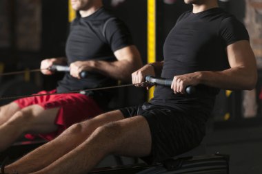 İki genç sporcuların spor salonunda egzersiz yukarı itin gerçekleştirme. Karanlık fotoğraf konsepti ile kopyalama alanı metin alanı.