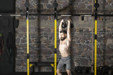 Genç sakallı ve gömleksiz atlet spor salonunda egzersiz için Ireland ile ısınıyor. Kopyalama alanı alanı konseptiyle karanlık fotoğraf. 