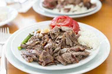 Türkçe ve Arapça geleneksel ramazan hünkar soslu dilimlenmiş ekmek, domates, ayran, yeşil biber ve pirinç veya ahşap masa arka plan üzerinde beyaz tabak içinde Türk pilav sıcak.