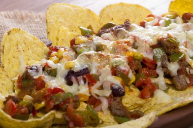 Meksika peynir, fasulye, Mısır, sıcak jalapeno, tavuk, kırmızı biber ve mantar ahşap masa üzerinde hizmet veren ile güveç pişmiş cips