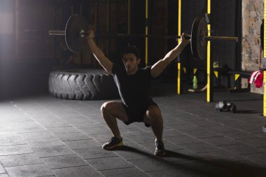 Erkek atlet koparma hareket jimnastik salonu pratik.