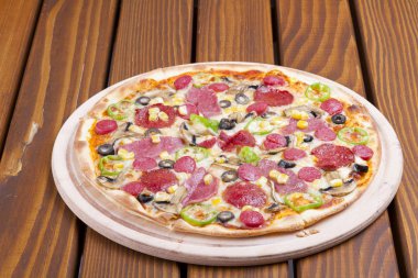 Pizza malzemeleri ile yeşil biber, sosis, jambon, mozzarella peyniri, siyah zeytin, Mısır ve ahşap masa arka plan üzerinde mantar dilimlenmiş. Üstten görünüm.