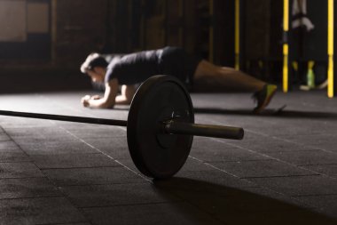 Plank. Spor salonunda egzersiz yaparken siyah spor giyim ve iş tahta pozisyonu giyen emin kaslı genç adam.