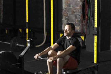 Bir spor salonunda egzersiz kadar genç sporcuların performans itmek. Karanlık fotoğraf konsepti ile kopyalama alanı metin alanı.