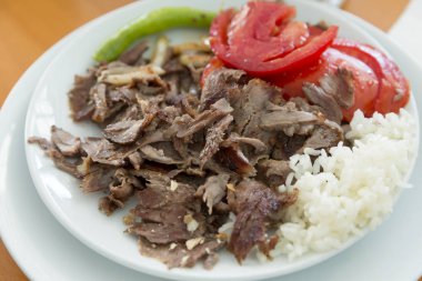 Türkçe ve Arapça geleneksel ramazan hünkar soslu dilimlenmiş ekmek, domates, ayran, yeşil biber ve pirinç veya ahşap masa arka plan üzerinde beyaz tabak içinde Türk pilav sıcak.