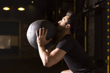 Spor salonunda bir tıp top ile duvar topu çekim pratik atlet.