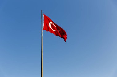 Türk bayrağı mavi gökyüzünde sallayarak uzun metal demir kutup. Kırmızı bayrak beyaz yıldız ve hilal featuring. Bayrak kez al bayrak denir ve al sancak Türk Milli Marşı olarak adlandırılır. 