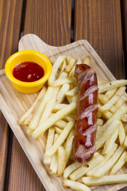 Izgara domuz eti frankfurter sosis kızartması, cips ve sos soslar ile üstten görünüm.