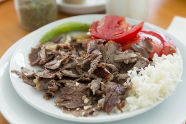Türkçe ve Arapça geleneksel ramazan hünkar soslu dilimlenmiş ekmek, domates, ayran, yeşil biber ve pirinç veya ahşap masa arka plan üzerinde beyaz tabak içinde Türk pilav sıcak.