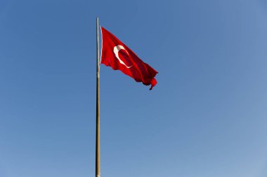 Türk bayrağı mavi gökyüzünde sallayarak uzun metal demir kutup. Kırmızı bayrak beyaz yıldız ve hilal featuring. Bayrak kez al bayrak denir ve al sancak Türk Milli Marşı olarak adlandırılır. 