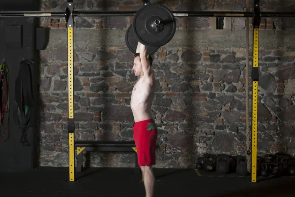 Atleta Masculino Topless Practicando Ascensores Olímpicos Gimnasio Con Fondo Pared — Foto de Stock