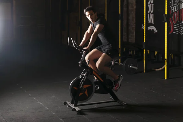 Joven Hombre Guapo Entrenamiento Bicicleta Deportiva Gimnasio Entrenamiento Con Paredes — Foto de Stock