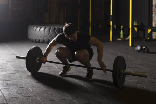 Male athlete practicing snatch movement at the gym.