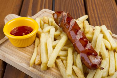 Izgara domuz eti frankfurter sosis kızartması, cips ve sos sos ile.