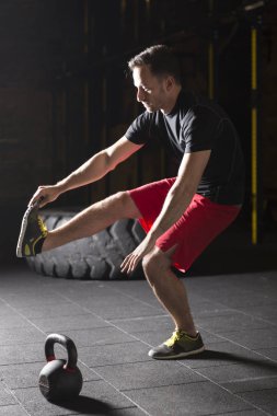 Tabanca pratik atlet spor salonunda squats. Karanlık fotoğraf konsepti ile kopyalama alanı metin alanı.