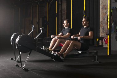 İki genç sporcuların spor salonunda egzersiz yukarı itin gerçekleştirme. Karanlık fotoğraf konsepti ile kopyalama alanı metin alanı.