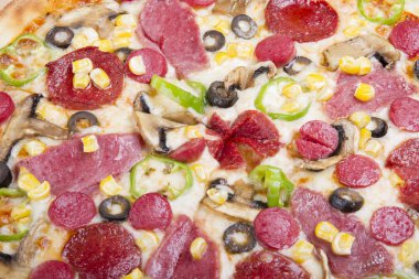 Ahşap masa arka plan üzerinde pizza malzemeleri yeşil biber, sosis, jambon, mozzarella peyniri, siyah zeytin, Mısır ve dilimlenmiş mantar ile yakın çekim. 