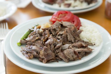 Türkçe ve Arapça geleneksel ramazan hünkar soslu dilimlenmiş ekmek, domates, ayran, yeşil biber ve pirinç veya ahşap masa arka plan üzerinde beyaz tabak içinde Türk pilav sıcak.