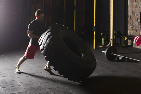 Black Shirt Man Flipping Big Heavy Tire Gym — Stock Photo, Image