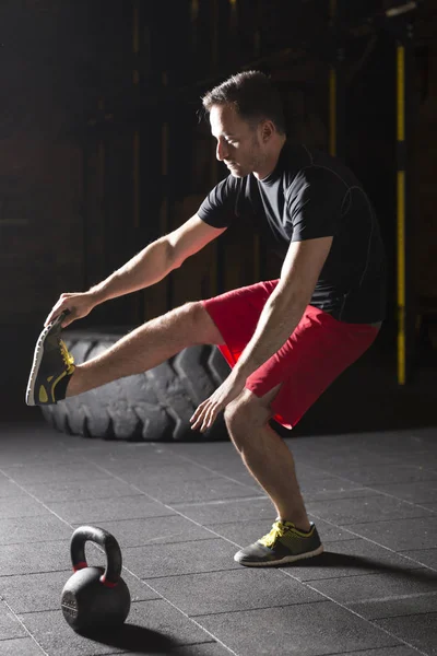 Tabanca pratik atlet spor salonunda squats. Karanlık fotoğraf konsepti ile kopyalama alanı metin alanı.