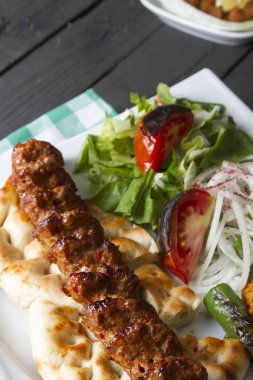 Türkçe ve Arapça geleneksel Adana Kebap sunumu salata ile bakış plaka üzerinde kapatın