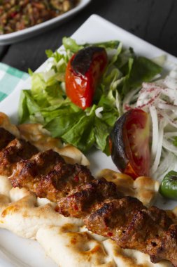 Türkçe ve Arapça geleneksel Adana Kebap sunumu salata ile bakış plaka üzerinde kapatın