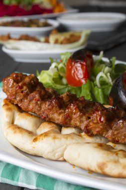 Türkçe ve Arapça geleneksel Adana Kebap sunumu salata ile bakış plaka üzerinde kapatın