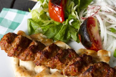 Türkçe ve Arapça geleneksel Adana Kebap sunumu salata ile bakış plaka üzerinde kapatın