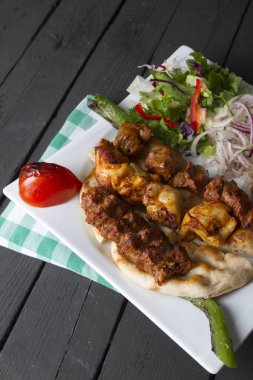 Türkçe ve Arapça geleneksel Adana Kebap sunumu ile salata plaka üzerinde