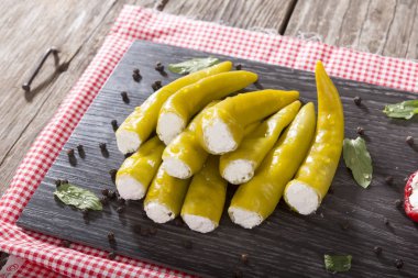 Yumuşak peynir Beyaz ahşap rustik arka plana sahip siyah koyu plaka üzerinde meze meze tatlı kiraz yeşil biber dolması.
