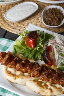 Türkçe ve Arapça geleneksel Adana Kebap sunumu salata ile bakış plaka üzerinde kapatın