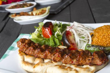 Türkçe ve Arapça geleneksel Adana Kebap sunumu salata ile bakış plaka üzerinde kapatın