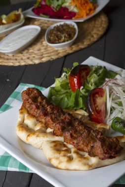 Türkçe ve Arapça geleneksel Adana Kebap sunumu salata ile bakış plaka üzerinde kapatın