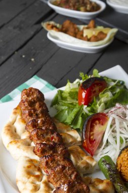Türkçe ve Arapça geleneksel Adana Kebap sunumu salata ile bakış plaka üzerinde kapatın