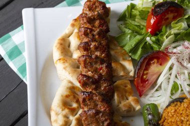 Türkçe ve Arapça geleneksel Adana Kebap sunumu salata ile bakış plaka üzerinde kapatın
