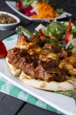 Türkçe ve Arapça geleneksel Adana Kebap sunumu ile salata plaka üzerinde