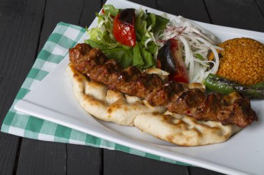 Türkçe ve Arapça geleneksel Adana Kebap sunumu salata ile bakış plaka üzerinde kapatın
